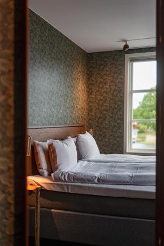 a bedroom with a bed and a window at Åhus Gästgivaregård in Åhus