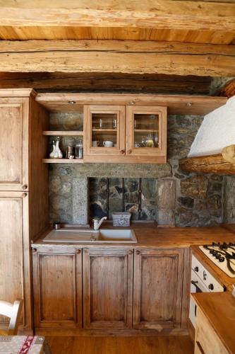 a kitchen with wooden cabinets and a sink at Albergo Diffuso Zoncolan in Ovaro