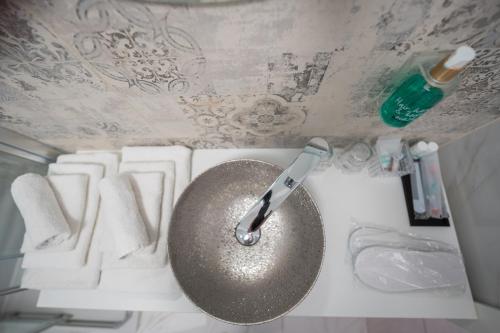 a bathroom sink with a knife on a wall at Pool and Breakfast Apartments Villa Maro in Novalja
