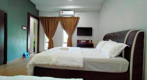 a bedroom with a large white bed in a room at OYO 89859 PP Traveller's Hotel in Pasir Puteh