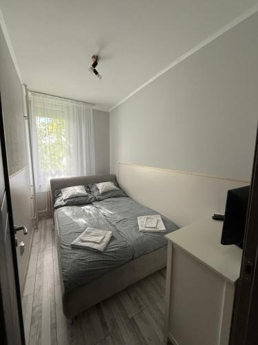 a small bedroom with a bed and a window at Boulevard Apartman in Nyíregyháza