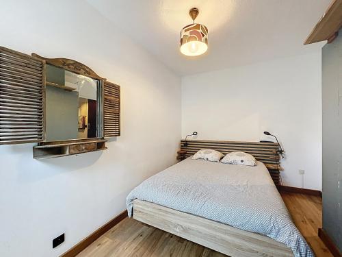 une chambre avec un lit et un miroir dans l'établissement Appartement rez de jardin proche du centre ville de sarzeau, à Sarzeau