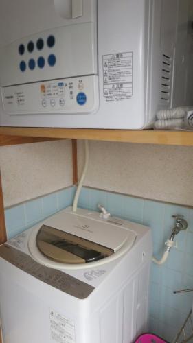 a microwave sitting on top of a washing machine at Aarons Guest House in Tanabe