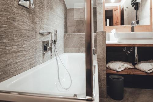 a bathroom with a white tub and a sink at Hotel Bouton d'Or - Courmayeur in Courmayeur