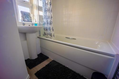 ein Badezimmer mit Waschbecken und Badewanne und Waschbecken in der Unterkunft Artisan Sanctuary in Lincoln