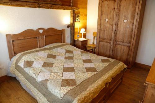 a bedroom with a bed with a checkered quilt at Albergo Diffuso Zoncolan in Ovaro