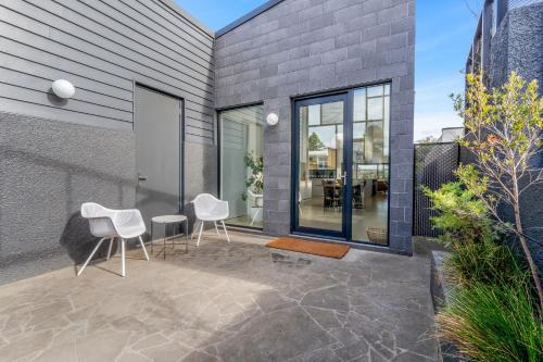 a patio with two chairs and a table at Allure - stunning in central Port Fairy in Port Fairy