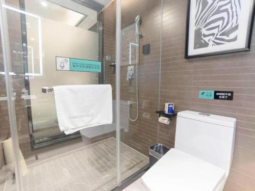 a bathroom with a glass shower and a toilet at Xana Hotelle Zhuhai Gongbei Port in Zhuhai
