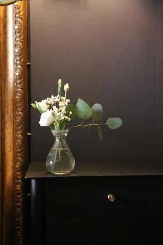 a vase filled with flowers sitting on a table at Åhus Gästgivaregård in Åhus