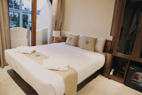 a bedroom with a large bed with white sheets and pillows at La Mer Bali Mui Ne in Phan Thiet