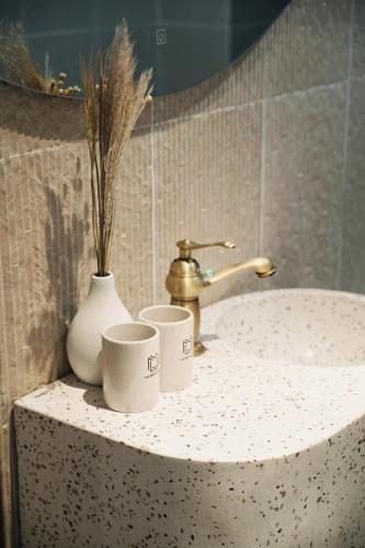 a bathroom sink with two cups and a faucet at La Mer Bali Mui Ne in Phan Thiet