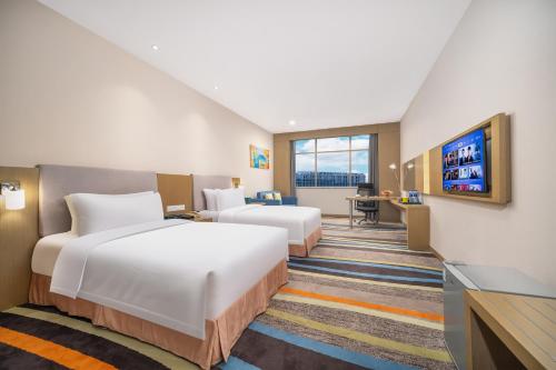 Postel nebo postele na pokoji v ubytování Guangzhou Baiyun Airport Rejoice by Argyle Hotel Rehe Metro Exit B --Free shuttle bus is provided during the 137th Canton Fair