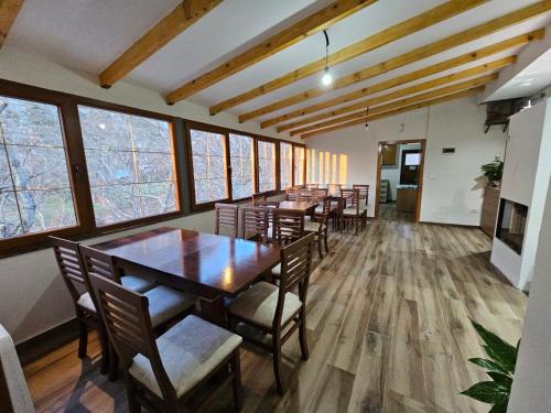 a dining room with tables and chairs and windows at Bujtina Goleci in Rabdisht