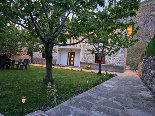 a garden with a stone walkway and two trees at Bujtina Goleci in Rabdisht