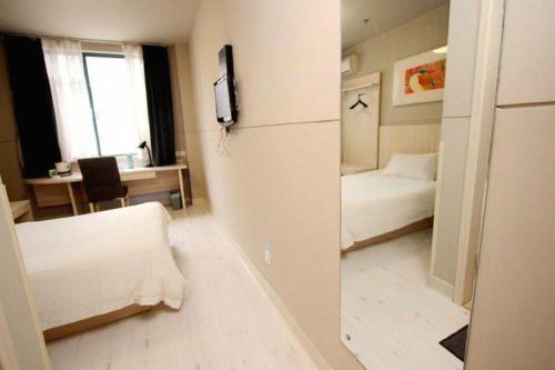 a small room with a bed and a desk with a table at JinJiang Inn Nanjing The Confucius Temple Zhonghuamen Metro Station in Nanjing