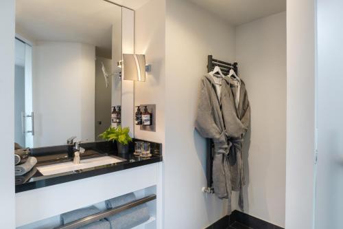 a bathroom with a sink and a mirror at INNSiDE by Meliá Wolfsburg in Wolfsburg