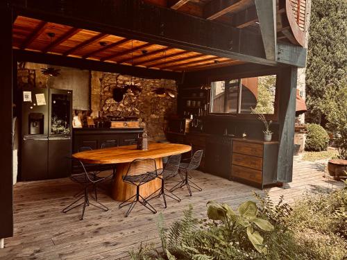 an outdoor kitchen with a wooden table and chairs at M&S - Maison FÉRAUD in Saint-Rémy-de-Provence