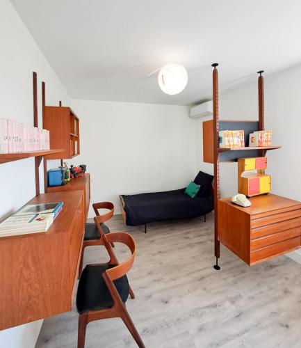 un salon avec un bureau et un canapé dans l'établissement Nonni - MAISON FAMILIALE AVEC JARDIN, PROCHE DE LA GARE ET A 10MIN DE LA PLAGE, à Royan