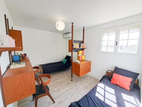 - un salon avec un lit et un bureau dans l'établissement Nonni - MAISON FAMILIALE AVEC JARDIN, PROCHE DE LA GARE ET A 10MIN DE LA PLAGE, à Royan