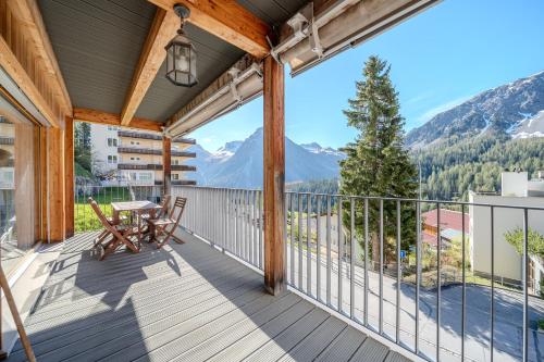 a balcony with a table and chairs and mountains at Sunnaschy Heidi by Arosa Vacations, Exklusive App nahe Skilift-Kulm mit Privatparkplatz in Arosa