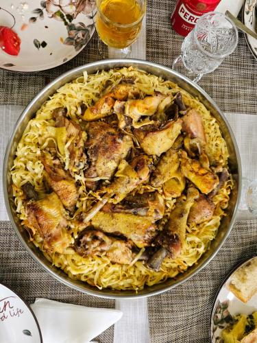 a pan of pasta with chicken and vegetables on a table at Bujtina Goleci in Rabdisht