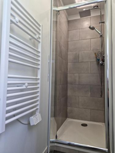 una ducha con puerta de cristal en un baño en Maison aux portes des garrigues, en Nimes