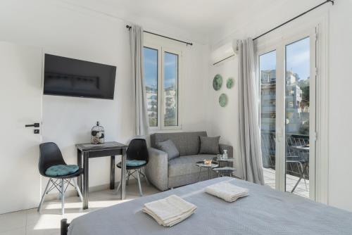 a white room with a bed and a couch and a couch at Chrysi Guesthouse in Rethymno