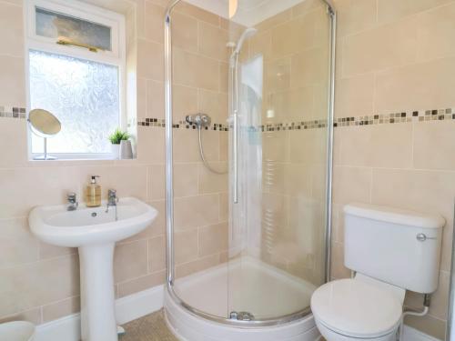 une salle de bains avec douche, toilettes et lavabo dans l'établissement Beer View Cottage, à Beer