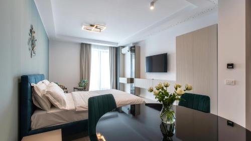 une chambre avec un lit et une table avec un vase de fleurs dans l'établissement Axxis Nova Resort & Spa, à Mamaia