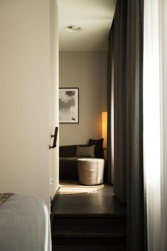 a bedroom with a bed and a couch at Boutique Hotel Beaumont Maastricht in Maastricht