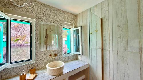 Utopia boutique villa on-in the water between 2 seas ideal 5 people في Kástron: حمام مع حوض ونافذة
