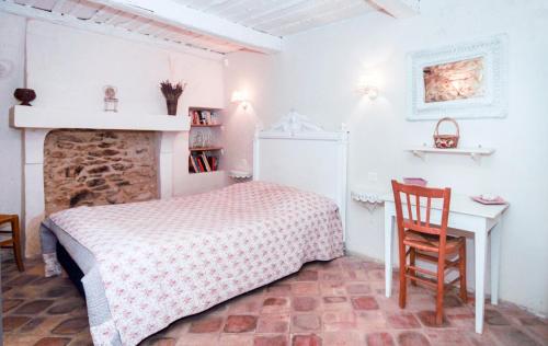 une chambre avec un lit, une table et une cheminée dans l'établissement Authentique Bergerie Coeur Luberon, à Lacoste