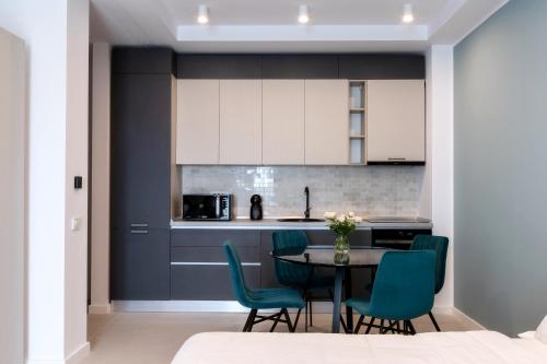 une cuisine avec une table et des chaises bleues dans l'établissement Axxis Nova Resort & Spa, à Mamaia