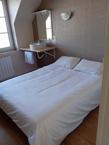 a large white bed in a small room at Le relais du Perche in Les Croix Chemins