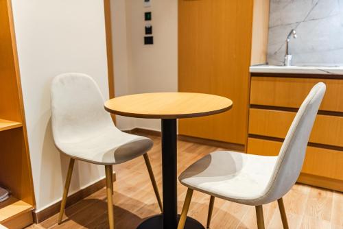 two white chairs and a table in a kitchen at Arbo Boutique Hotel in Durrës