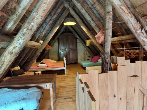 Cette chambre mansardée comprend plusieurs lits. dans l'établissement La Chaumière aux Biches, à La Celle-sous-Gouzon