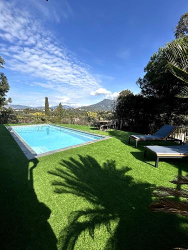 - une piscine dans une cour avec de l'herbe verte dans l'établissement Luxe et nature, paradis Corse, à Cauro