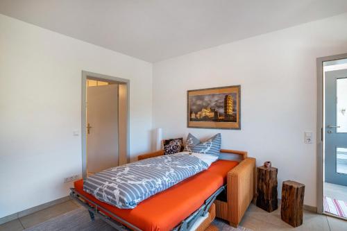 a bedroom with a bed with an orange bench at Ferienwohnung Kuckuckslockennest in Seebach