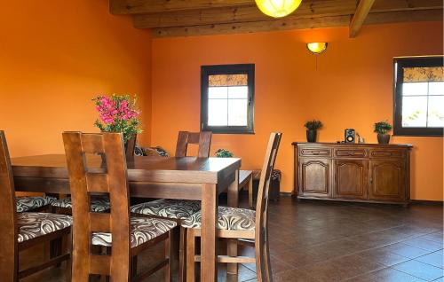 a dining room with a wooden table and chairs at Nice Home In Podamirowo With Lake View in Podamirowo