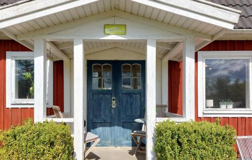 a blue front door of a red house at 2 Bedroom Cozy Home In Unnaryd in Sunnaryd
