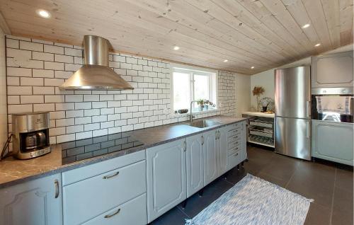 a kitchen with white cabinets and stainless steel appliances at 2 Bedroom Cozy Home In Unnaryd in Sunnaryd