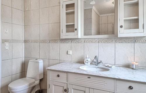 a white bathroom with a toilet and a sink at 4 Bedroom Cozy Home In Flo in Flo