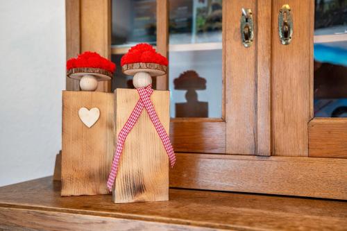 two wooden figurines with hats on top of a cabinet at Ferienwohnung Kuckuckslockennest in Seebach