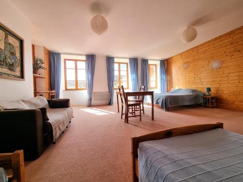 a bedroom with a bed and a table and chairs at Le Clos de l'Atre in La Chaise-Dieu