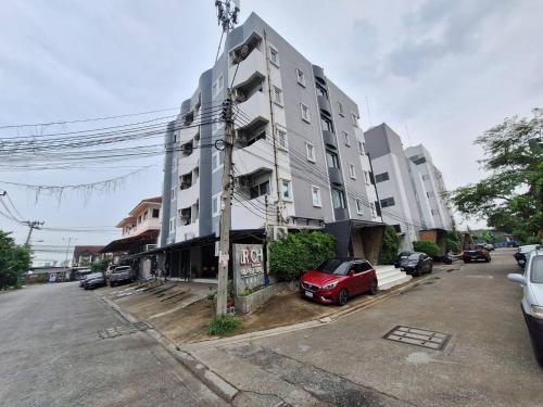 a building with a red car parked in front of it at Irich Bang Hua Suae 6kms from BTS Pu-Chao in Ban Bang Chak