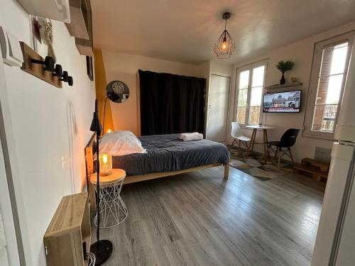 Cet appartement comprend une chambre avec un lit et un salon avec une table. dans l'établissement Lemon Roof top, à Troyes