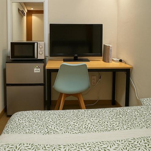 a desk with a television and a chair in a room at Singil house in Seoul