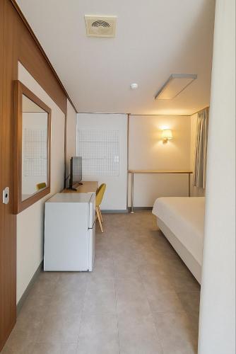 a room with a bed and a desk with a computer at Singil house in Seoul