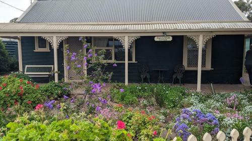 a blue house with a garden of flowers at Schoolhouse Cottage - American River in American River