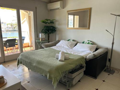 a bedroom with a bed and a couch and a mirror at Maena San Maurici Lago in Empuriabrava